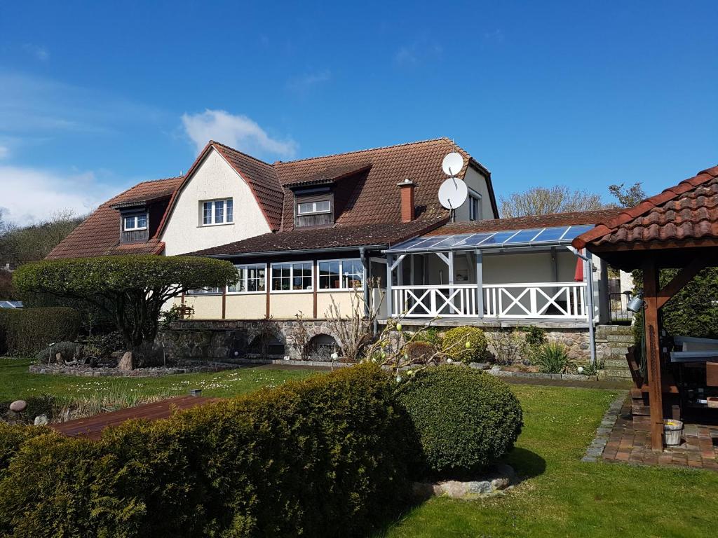 ein großes weißes Haus mit einem Dach in der Unterkunft Ferienhaus Hasenhügel mit Seeblick in Schwedt