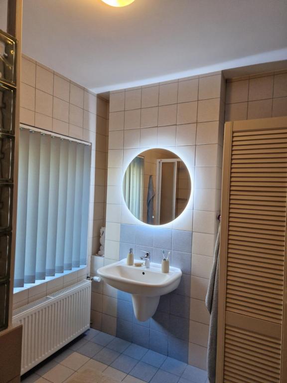 ein Badezimmer mit Waschbecken und Spiegel in der Unterkunft Ferienhaus Hasenhügel mit Seeblick in Schwedt
